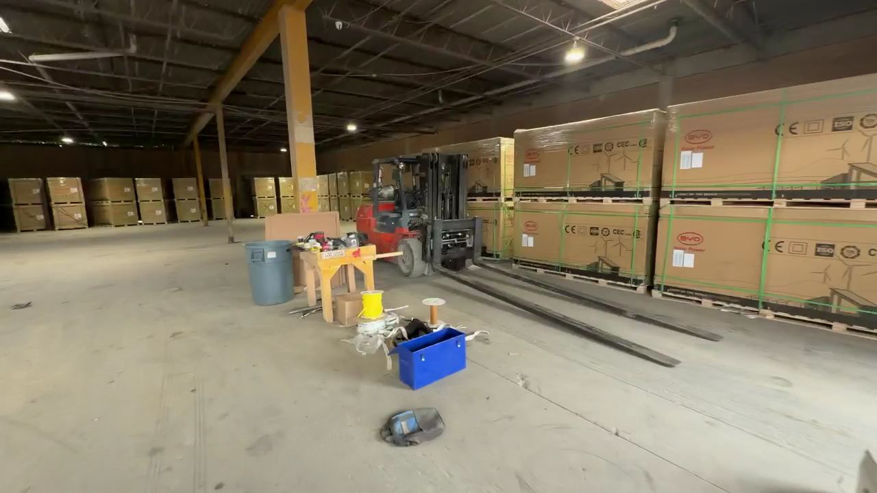 A forklift moving palletized cargo inside the Ajeeb Overseas warehouse